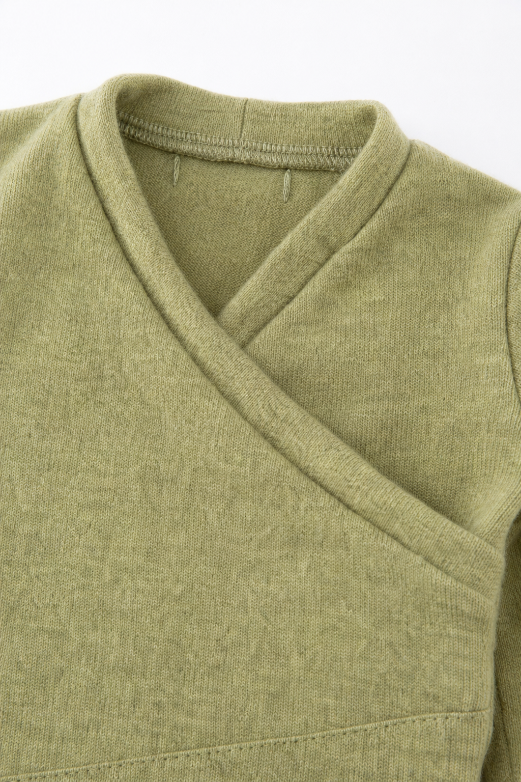 Detailaufnahme des Kaschmir Baby Longsleeves in Gelb, Größe 62/68