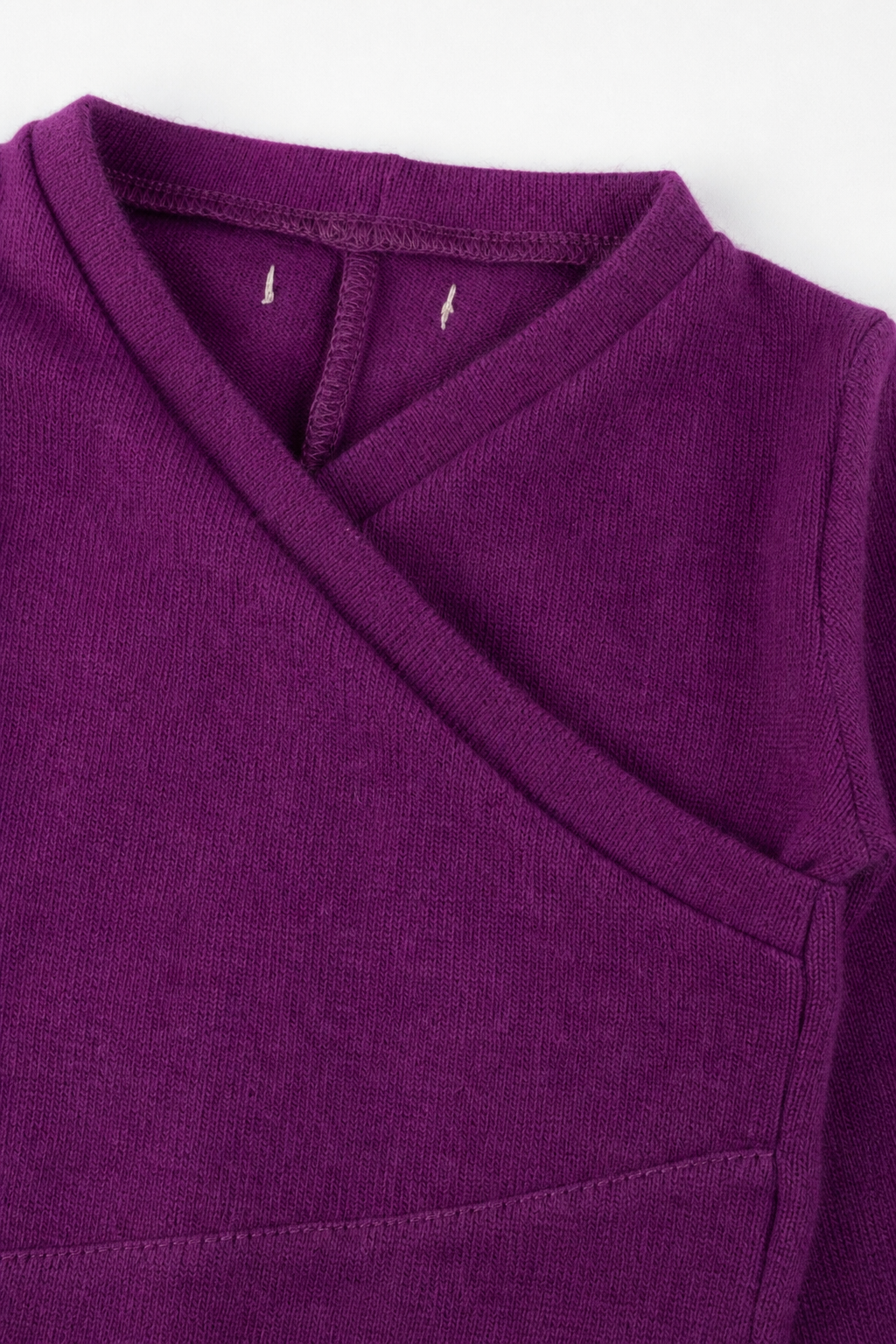 Detailaufnahme des Kaschmir Baby Longsleeves in Lila, Größe 62/68
