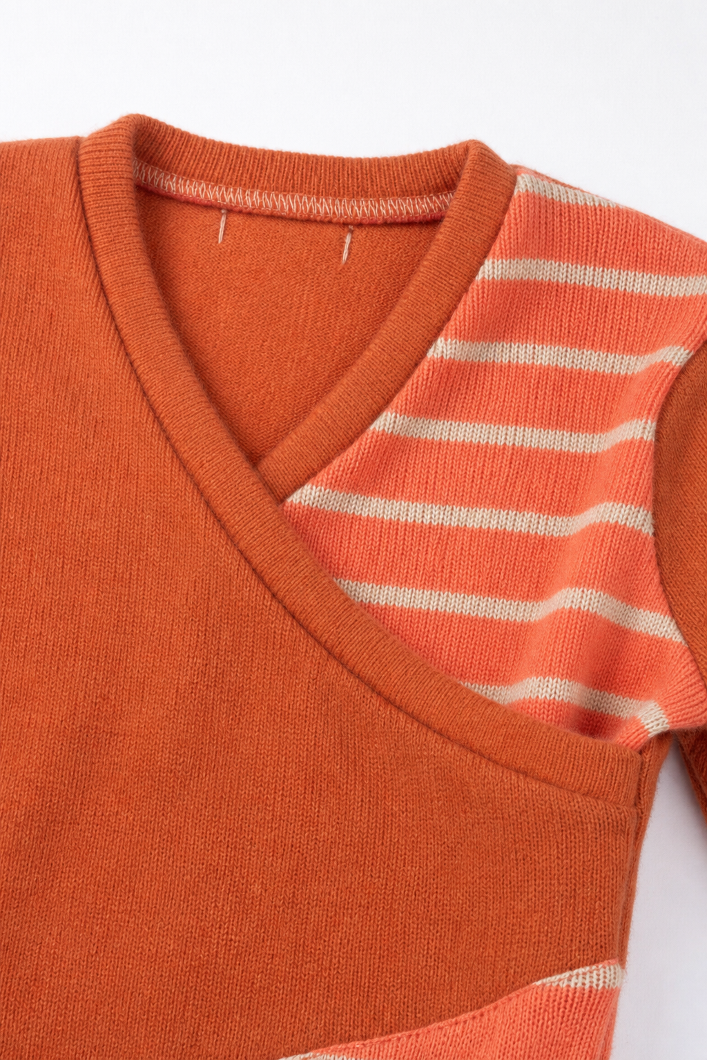 Detailaufnahme des Kaschmir Baby Longsleeves in Orange, Größe 86/92
