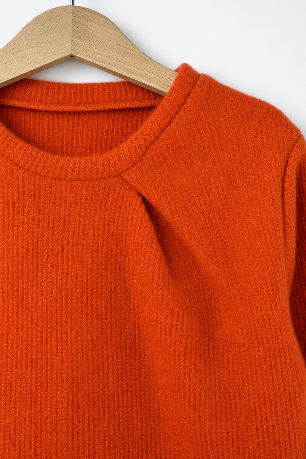 Detailaufnahme des Kaschmir Pullovers mit der Falte in Orange